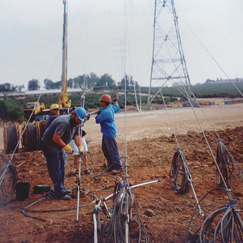 Workers install anchors for guy wires